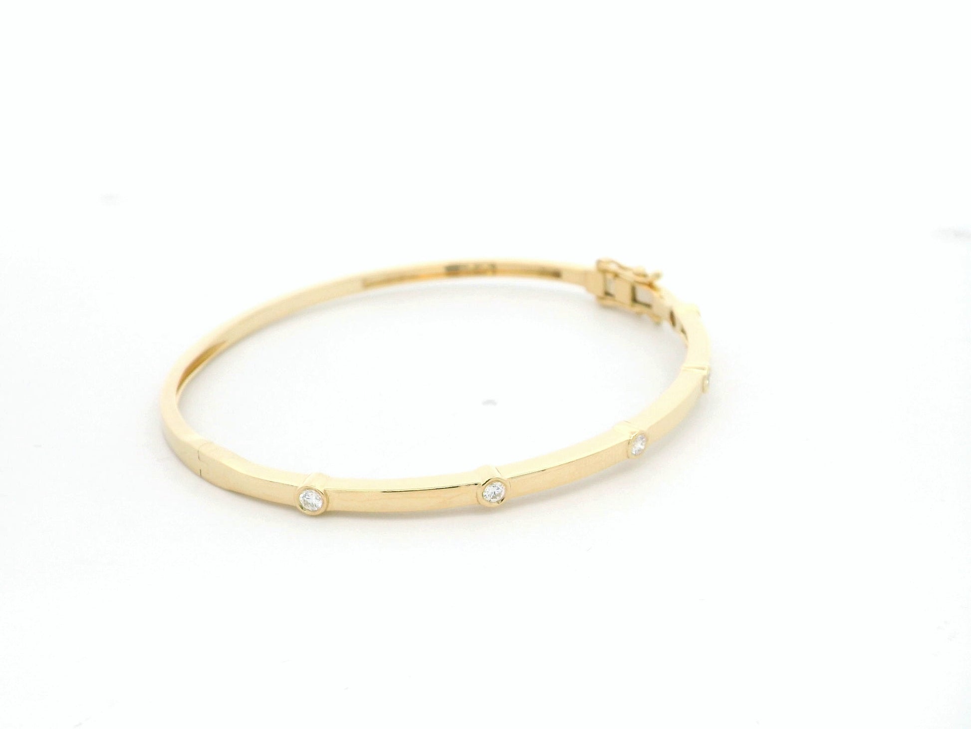 Minimal diamond bangle bracelet in 18K yellow gold with bezel-set natural diamonds