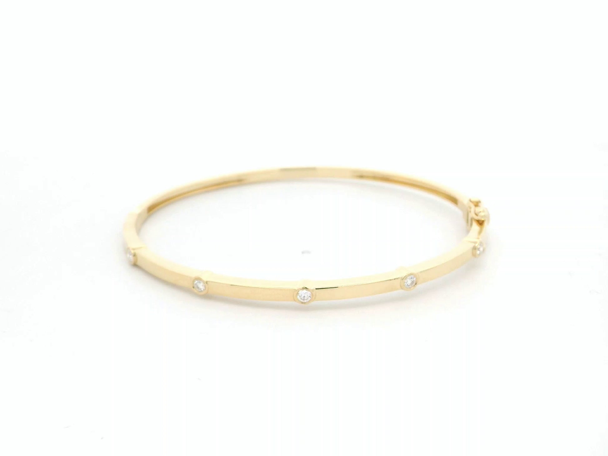 Minimal diamond bangle bracelet in 18K yellow gold with bezel-set natural diamonds