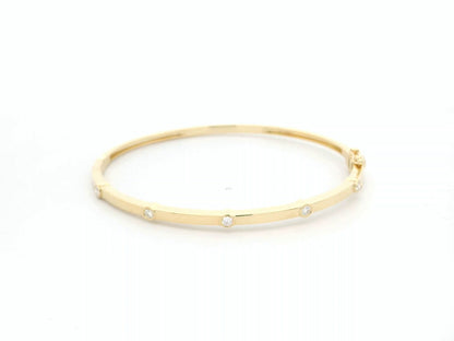 Minimal diamond bangle bracelet in 18K yellow gold with bezel-set natural diamonds