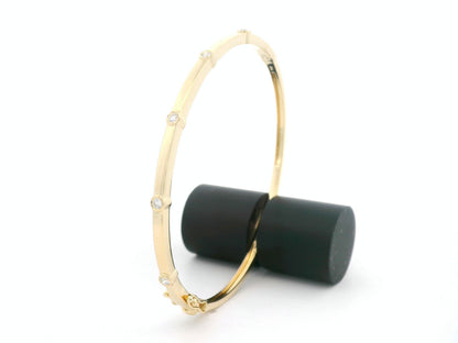 Minimal diamond bangle bracelet in 18K yellow gold with bezel-set natural diamonds