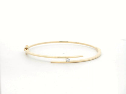 18K yellow gold rigid open bangle with tension-set 0.10 carat diamond by Emirates Diamonds