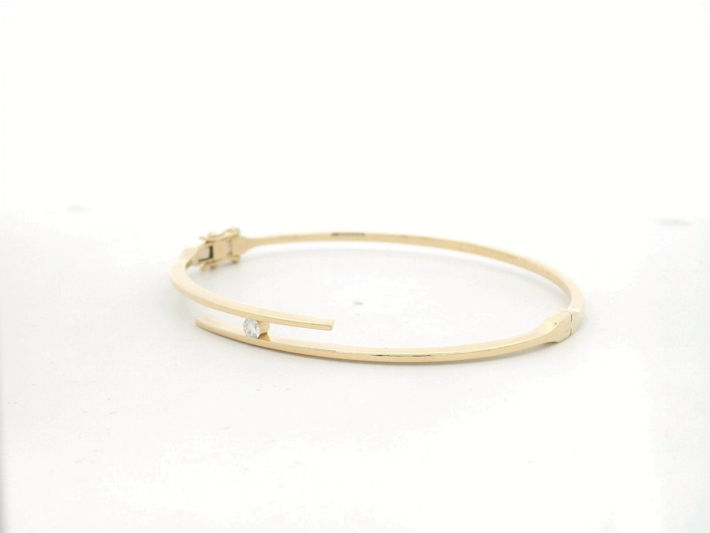 18K yellow gold rigid open bangle with tension-set 0.10 carat diamond by Emirates Diamonds