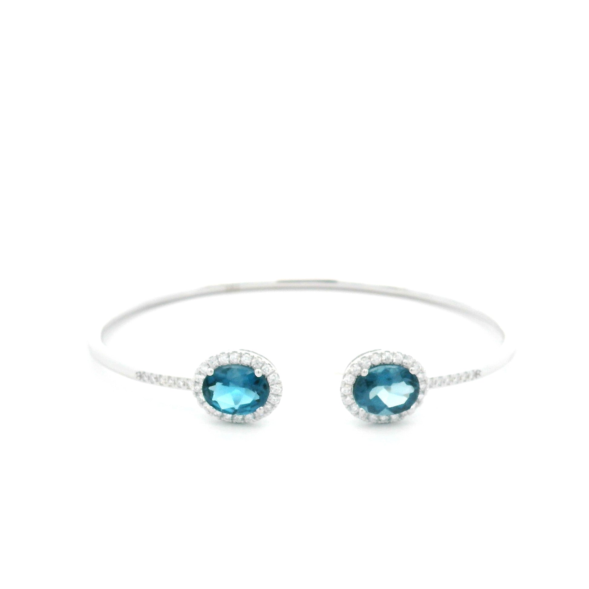 18K white gold open cuff bangle featuring two oval natural London Blue Topaz gemstones totaling 4.21 carats, surrounded by natural diamond halos totaling 0.57 carat.