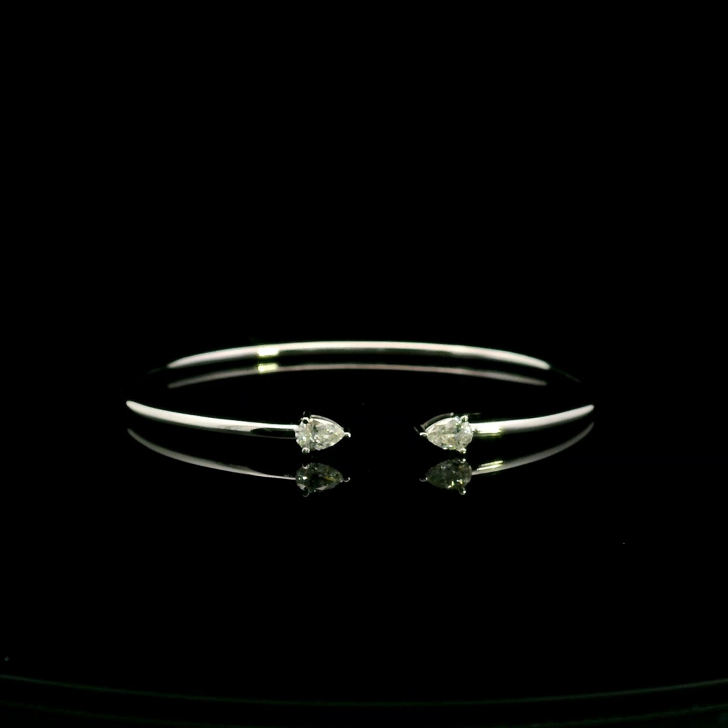18K white gold open cuff bangle featuring pear-shaped natural diamonds with a total diamond weight of 0.61 Carat.
