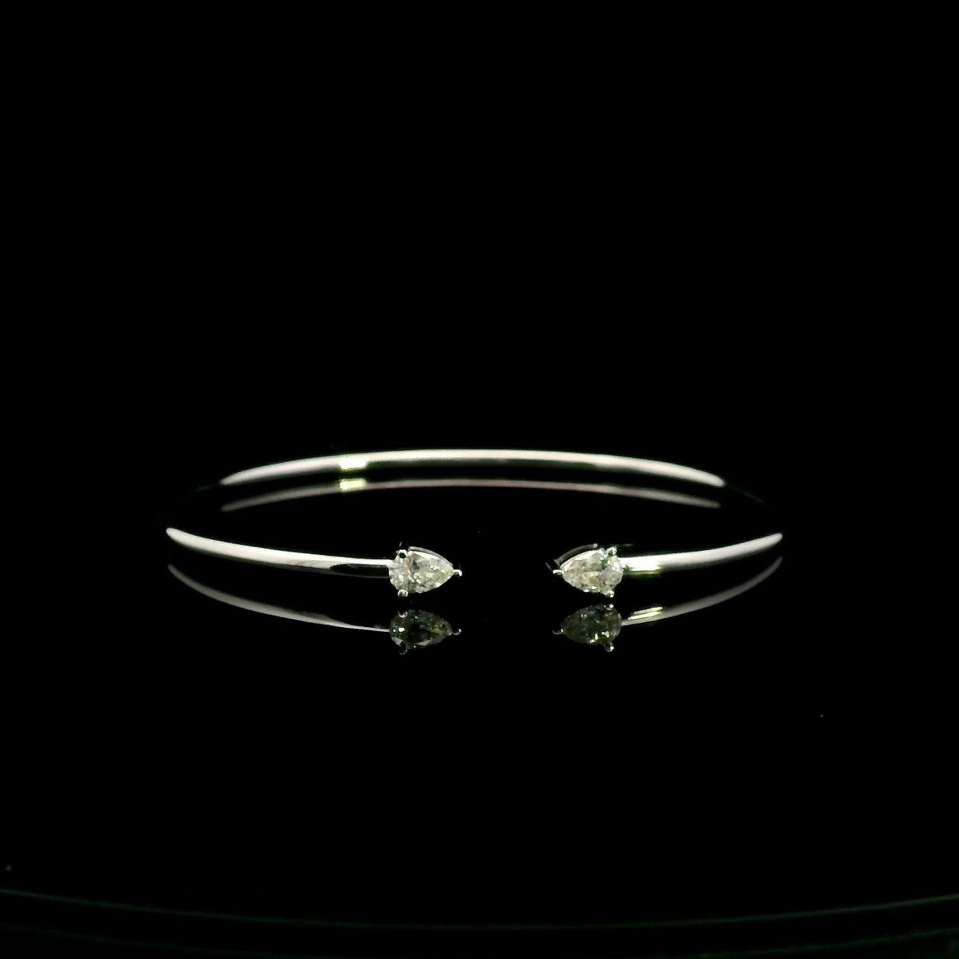 18K white gold open cuff bangle featuring pear-shaped natural diamonds with a total diamond weight of 0.61 Carat.