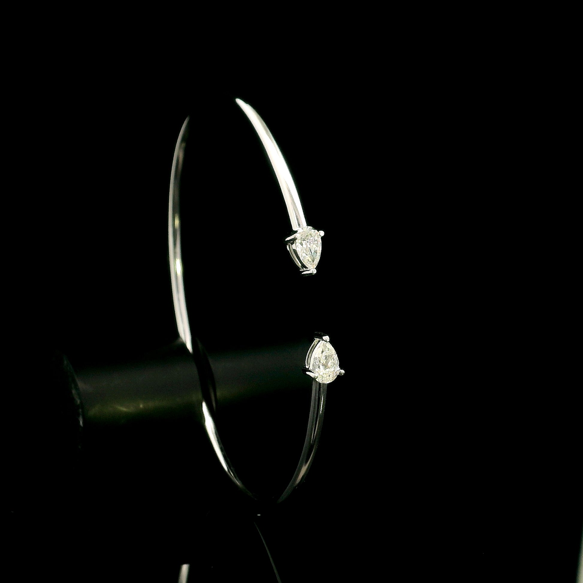18K white gold open cuff bangle featuring pear-shaped natural diamonds with a total diamond weight of 0.61 Carat.