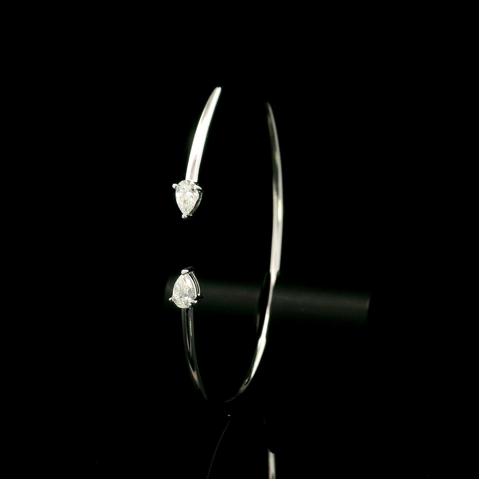 18K white gold open cuff bangle featuring pear-shaped natural diamonds with a total diamond weight of 0.61 Carat.