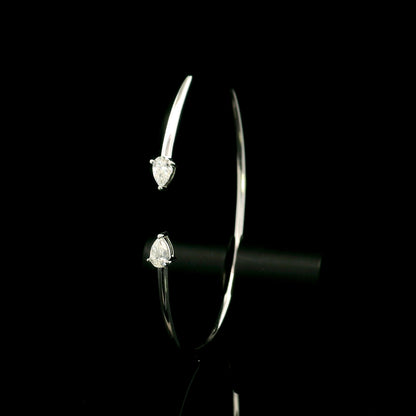 18K white gold open cuff bangle featuring pear-shaped natural diamonds with a total diamond weight of 0.61 Carat.
