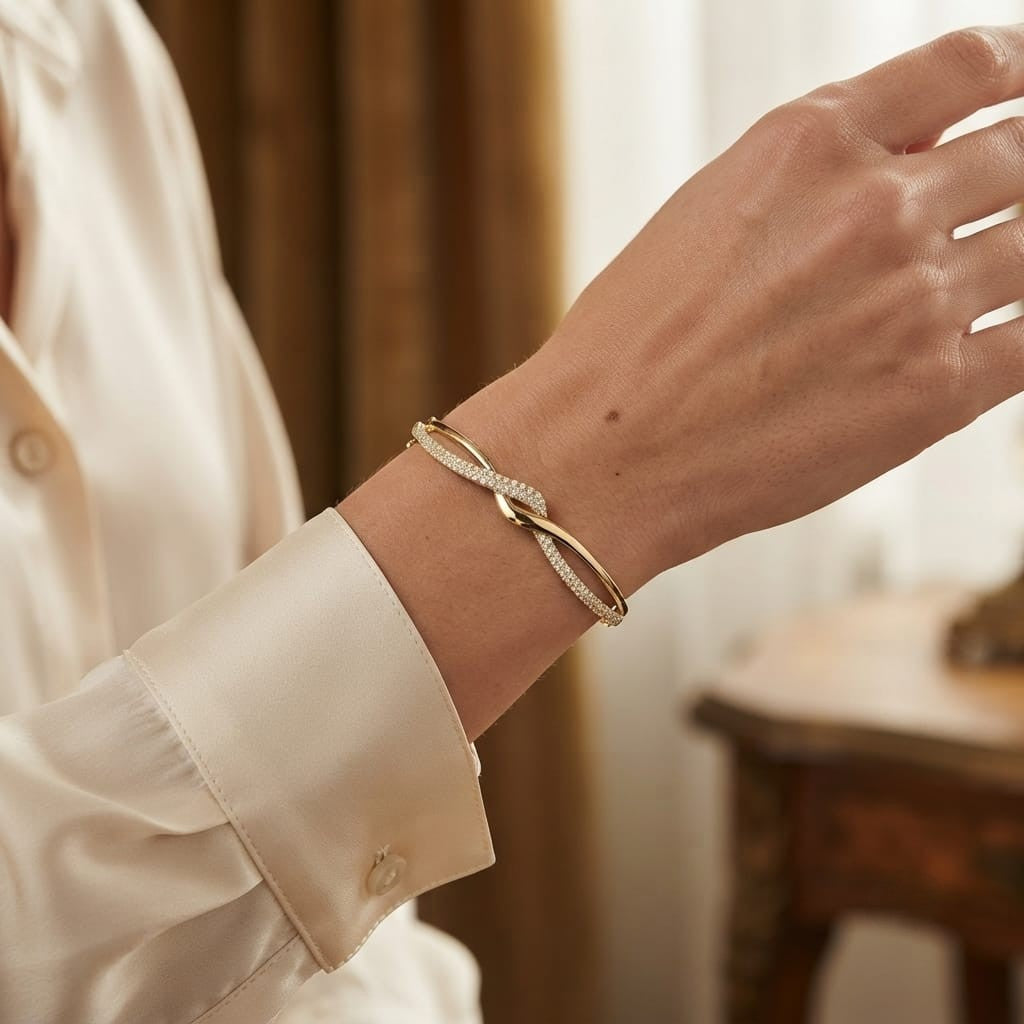 18K yellow gold diamond crossover bangle with intertwined polished and pavé diamond-set sections.