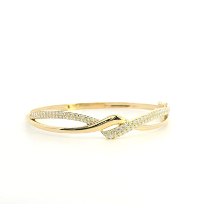 18K yellow gold diamond crossover bangle with intertwined polished and pavé diamond-set sections.