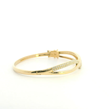 18K yellow gold diamond crossover bangle with intertwined polished and pavé diamond-set sections.