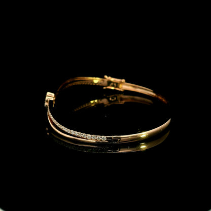 18K rose gold double row diamond bangle with flowing wave design, pavé diamond detailing and central floral diamond motif.
