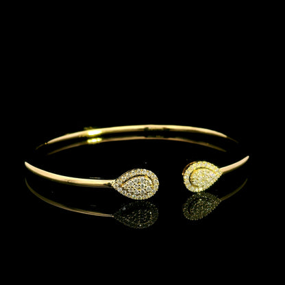 18K yellow gold open diamond bangle with twin pear-shaped diamond cluster ends.