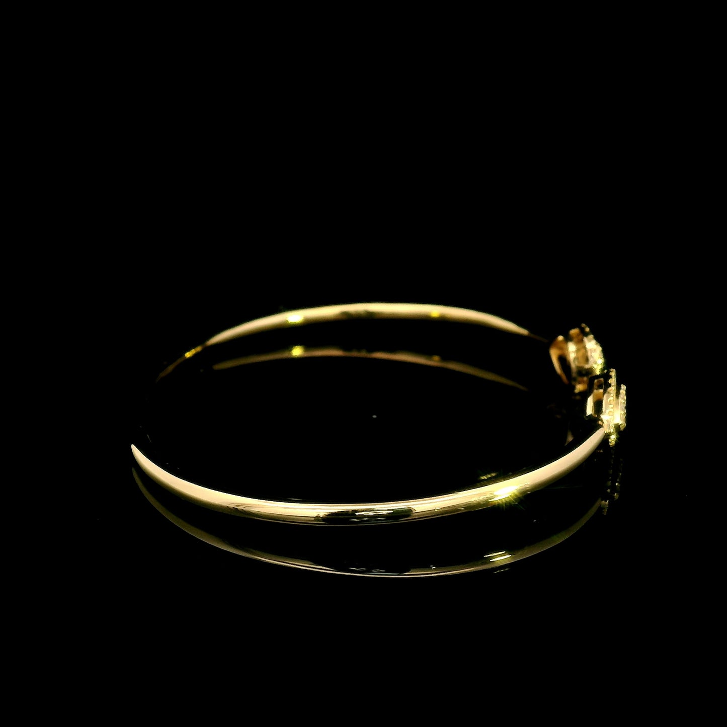 18K yellow gold open diamond bangle with twin pear-shaped diamond cluster ends.