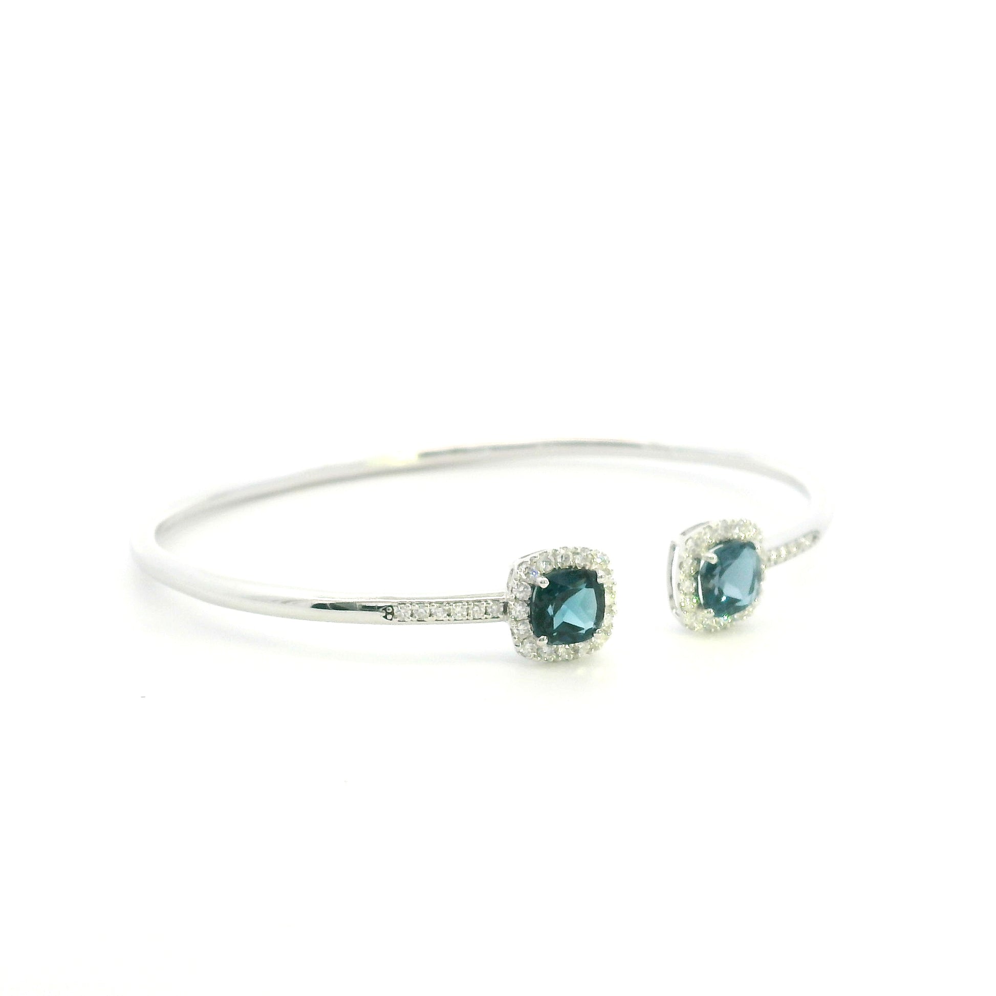 London Blue Topaz and diamond open bangle in 18K white gold with two cushion-cut blue topaz gemstones and diamond surrounds