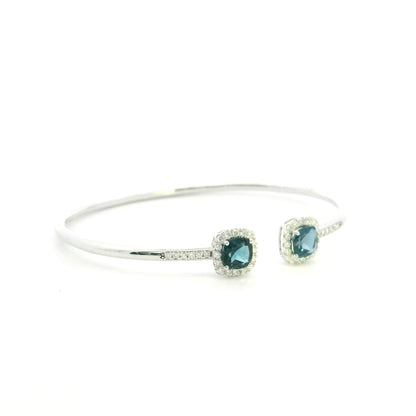 London Blue Topaz and diamond open bangle in 18K white gold with two cushion-cut blue topaz gemstones and diamond surrounds
