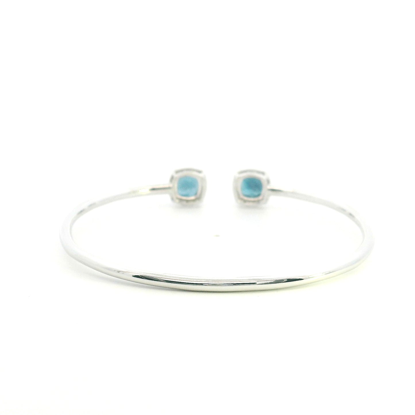 London Blue Topaz and diamond open bangle in 18K white gold with two cushion-cut blue topaz gemstones and diamond surrounds
