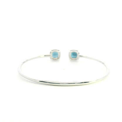 London Blue Topaz and diamond open bangle in 18K white gold with two cushion-cut blue topaz gemstones and diamond surrounds