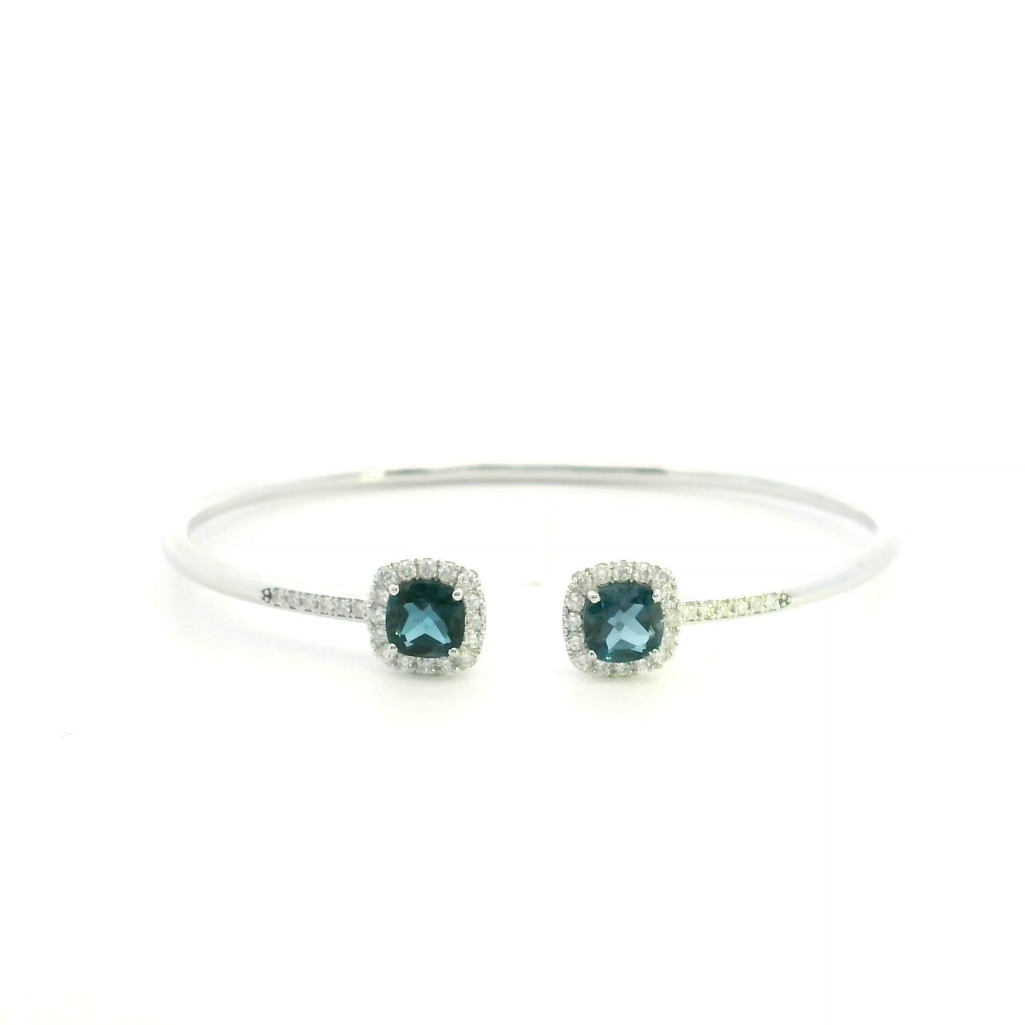 London Blue Topaz and diamond open bangle in 18K white gold with two cushion-cut blue topaz gemstones and diamond surrounds