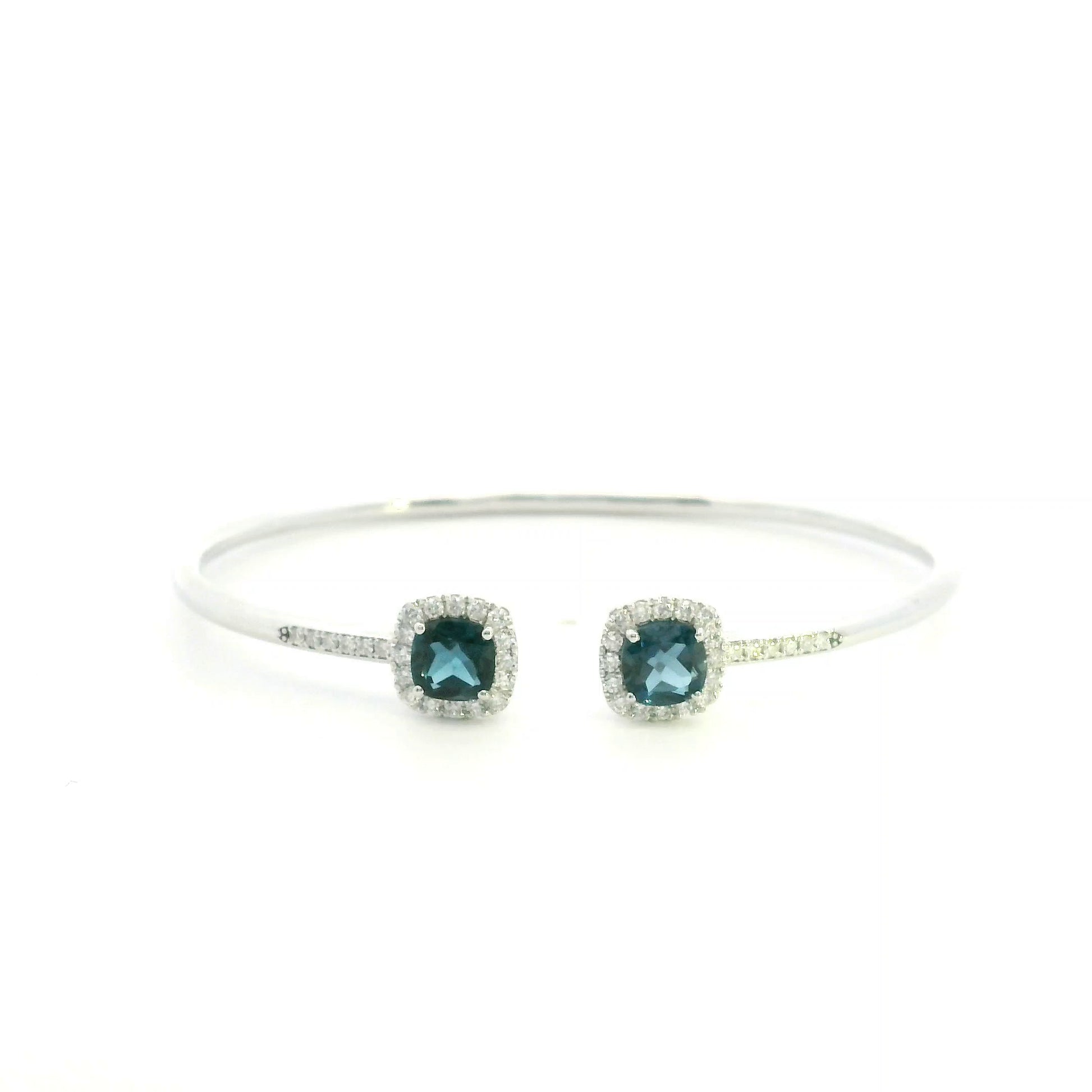 London Blue Topaz and diamond open bangle in 18K white gold with two cushion-cut blue topaz gemstones and diamond surrounds