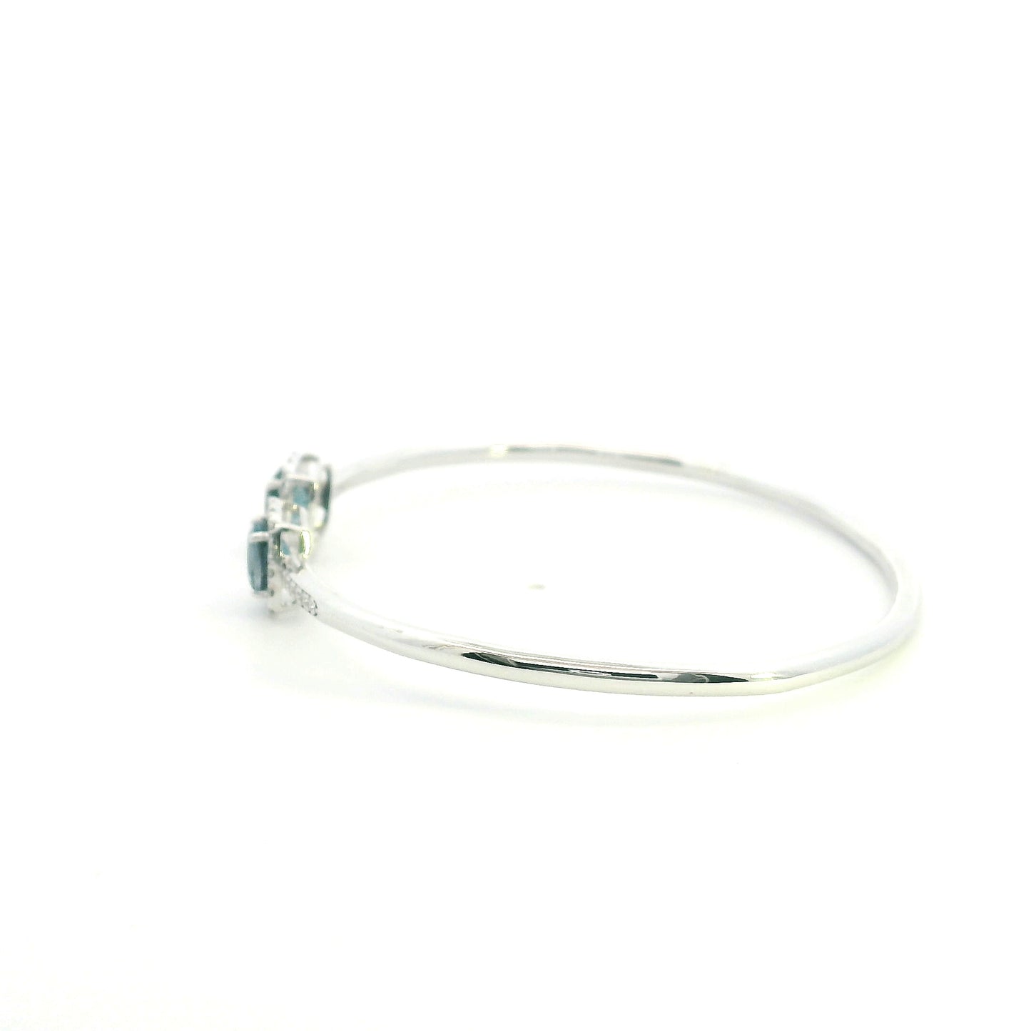 London Blue Topaz and diamond open bangle in 18K white gold with two cushion-cut blue topaz gemstones and diamond surrounds