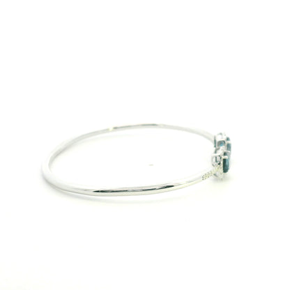 London Blue Topaz and diamond open bangle in 18K white gold with two cushion-cut blue topaz gemstones and diamond surrounds