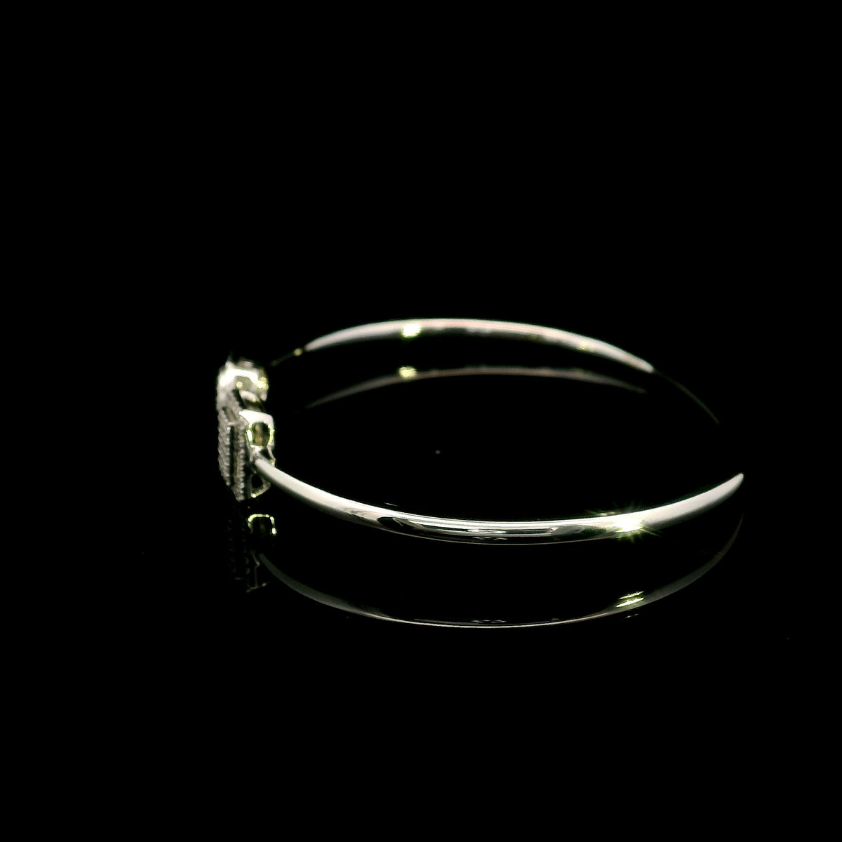 Geometric diamond open bangle in 18K white gold with contrasting pear-shaped and rectangular diamond motifs.