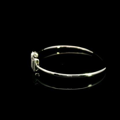 Geometric diamond open bangle in 18K white gold with contrasting pear-shaped and rectangular diamond motifs.