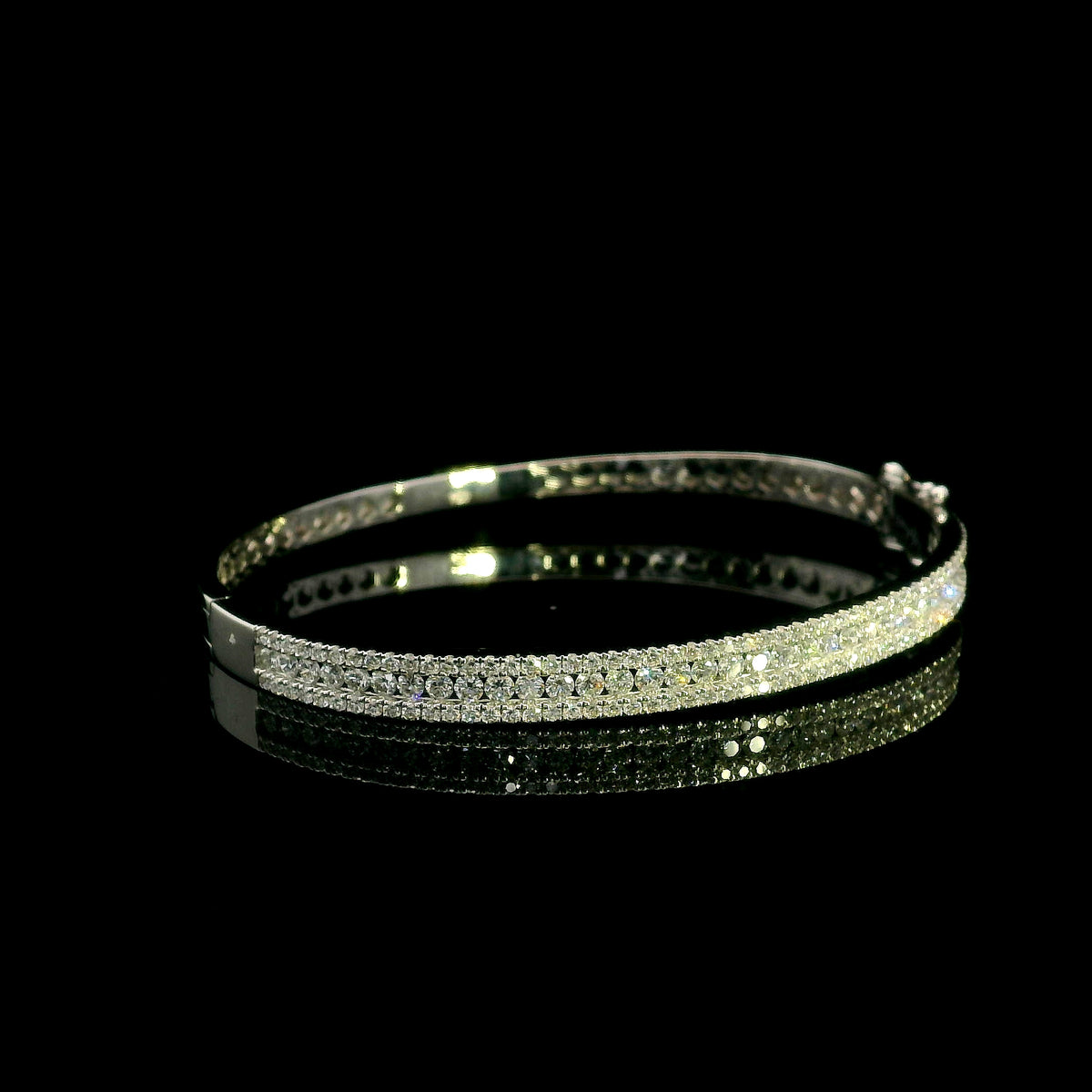 Three row diamond bangle in 18K white gold with parallel rows of round diamonds across the front.