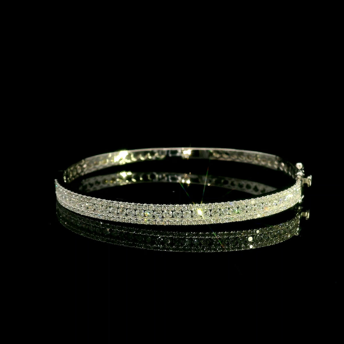 Three row diamond bangle in 18K white gold with parallel rows of round diamonds across the front.