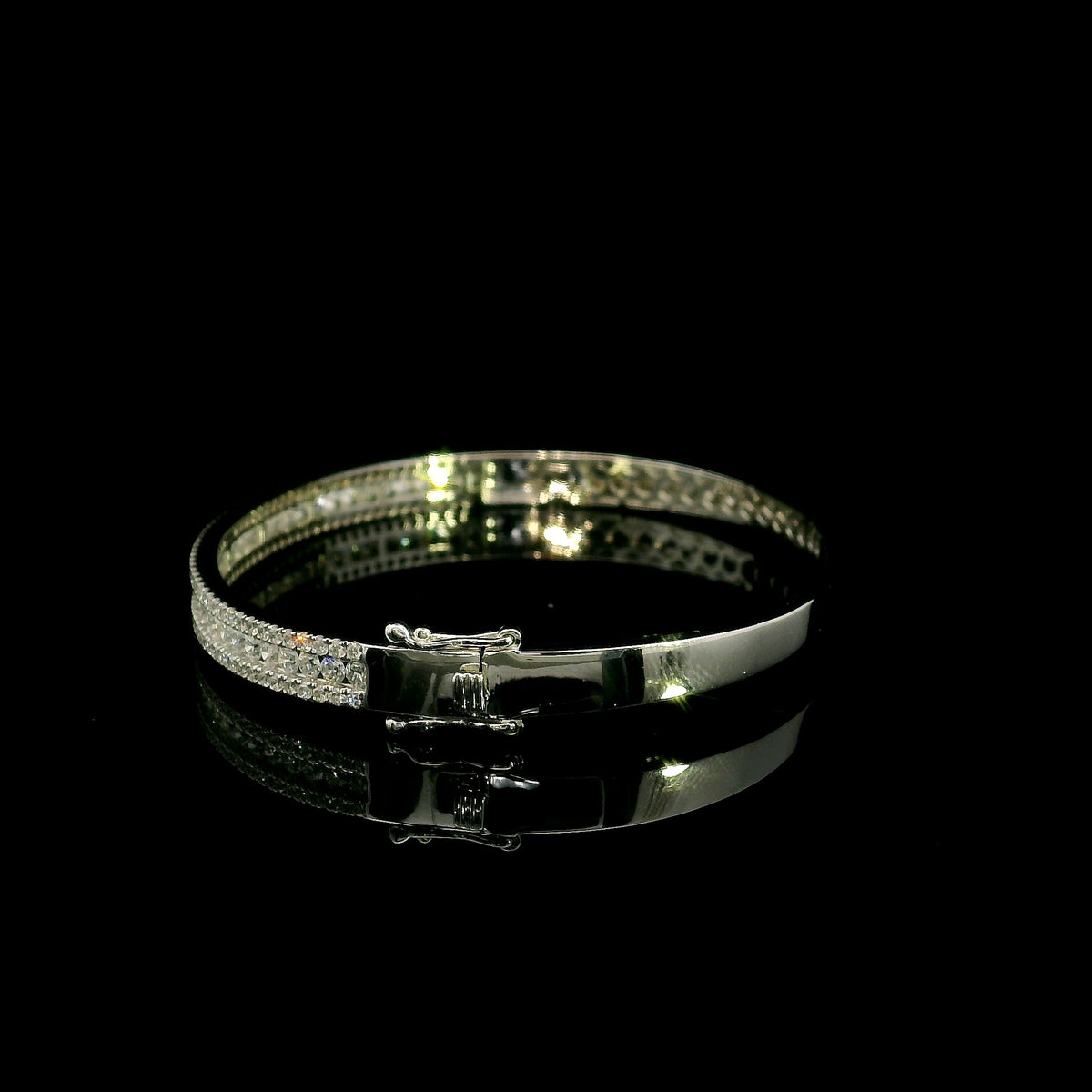 Three row diamond bangle in 18K white gold with parallel rows of round diamonds across the front.