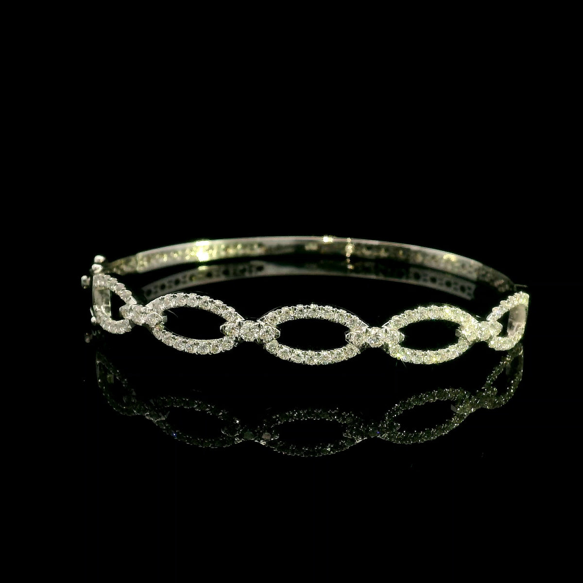Diamond loop bangle in 18K white gold with repeating diamond-set open loops across the front.