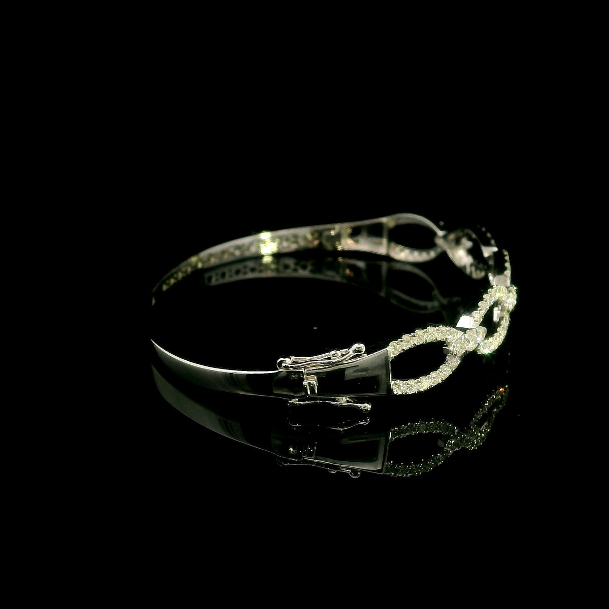 Diamond loop bangle in 18K white gold with repeating diamond-set open loops across the front.