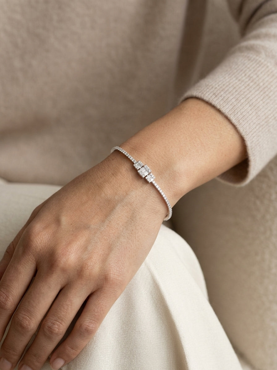 Baguette and round diamond bangle in 18K white gold with three geometric diamond centre motifs.