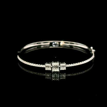 Baguette and round diamond bangle in 18K white gold with three geometric diamond centre motifs.