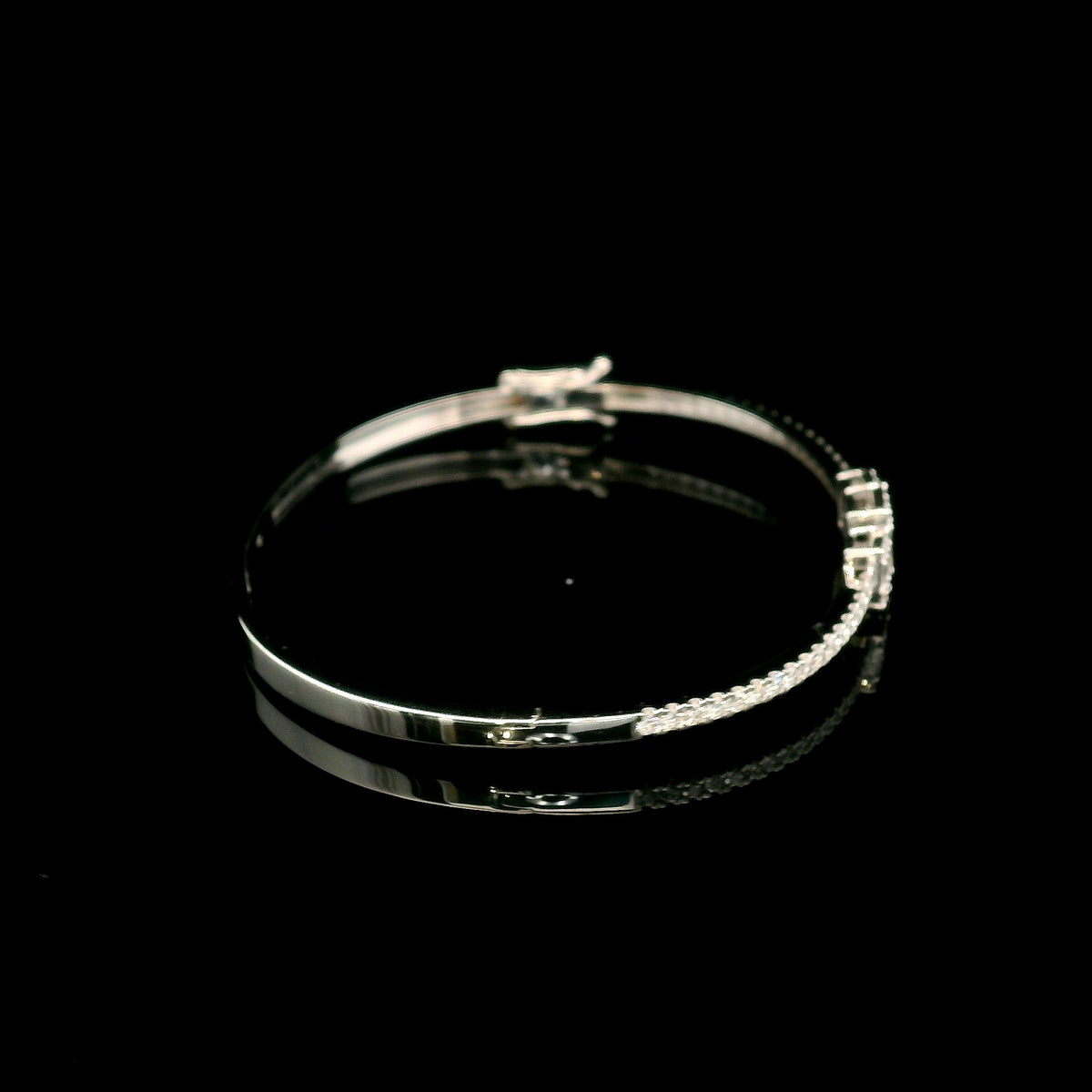 Baguette and round diamond bangle in 18K white gold with three geometric diamond centre motifs.
