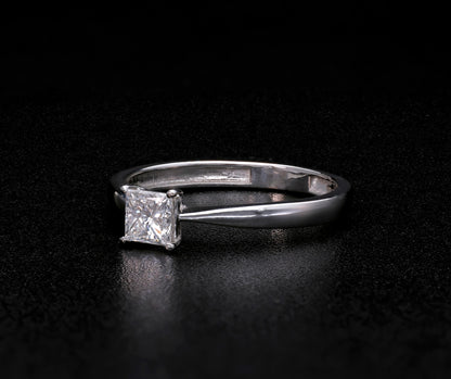 Princess cut diamond solitaire engagement ring in 18K white gold featuring a square diamond in a four-prong setting with a polished band.