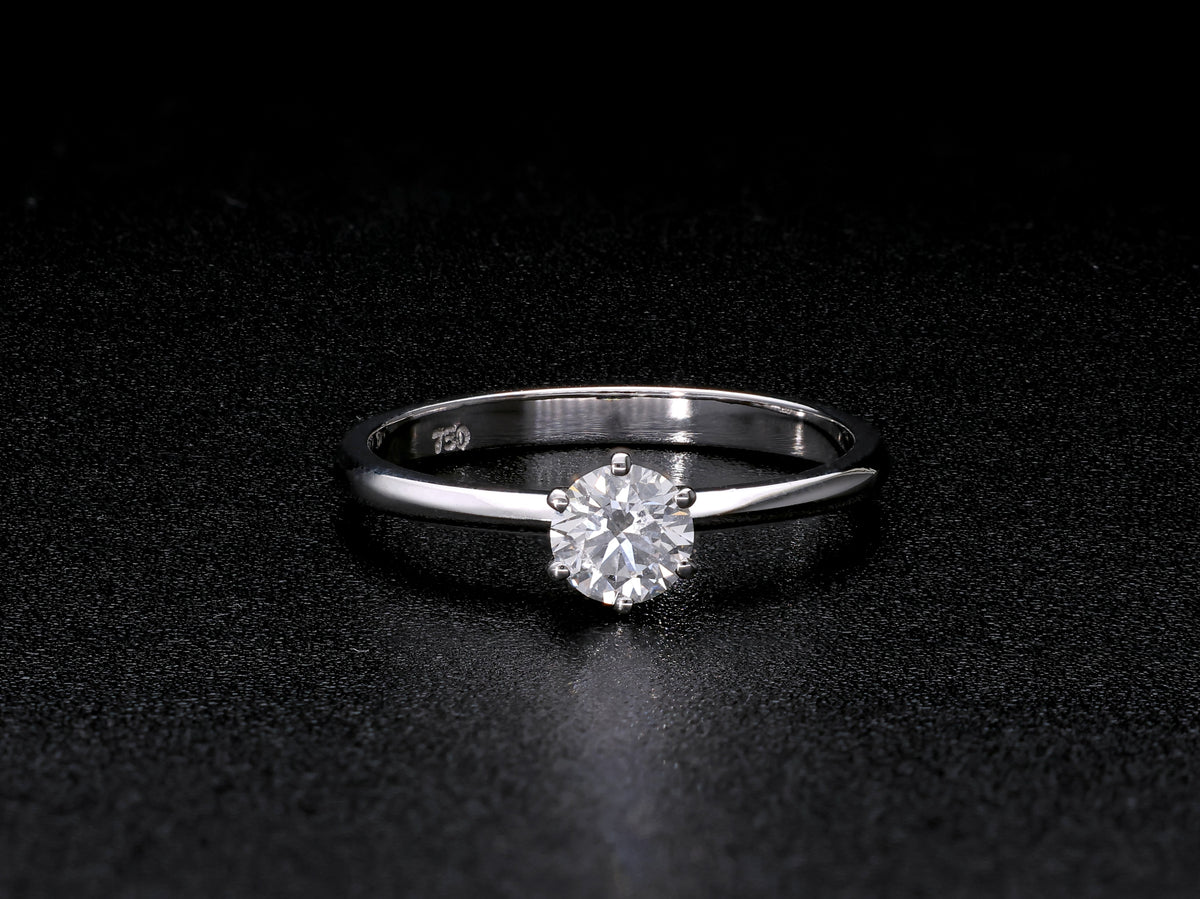 Round brilliant cut diamond solitaire engagement ring in 18K white gold featuring a 0.50 carat natural diamond in a six-prong setting on a slim polished band.