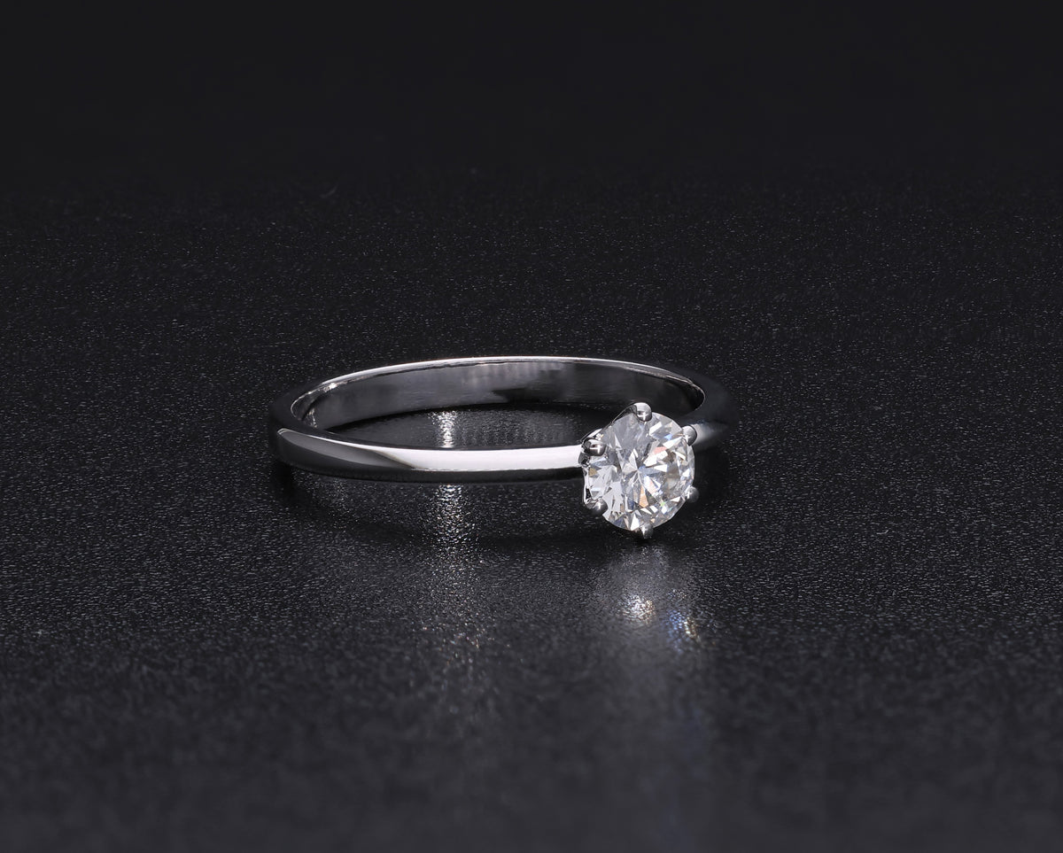 Round brilliant cut diamond solitaire engagement ring in 18K white gold featuring a 0.50 carat natural diamond in a six-prong setting on a slim polished band.