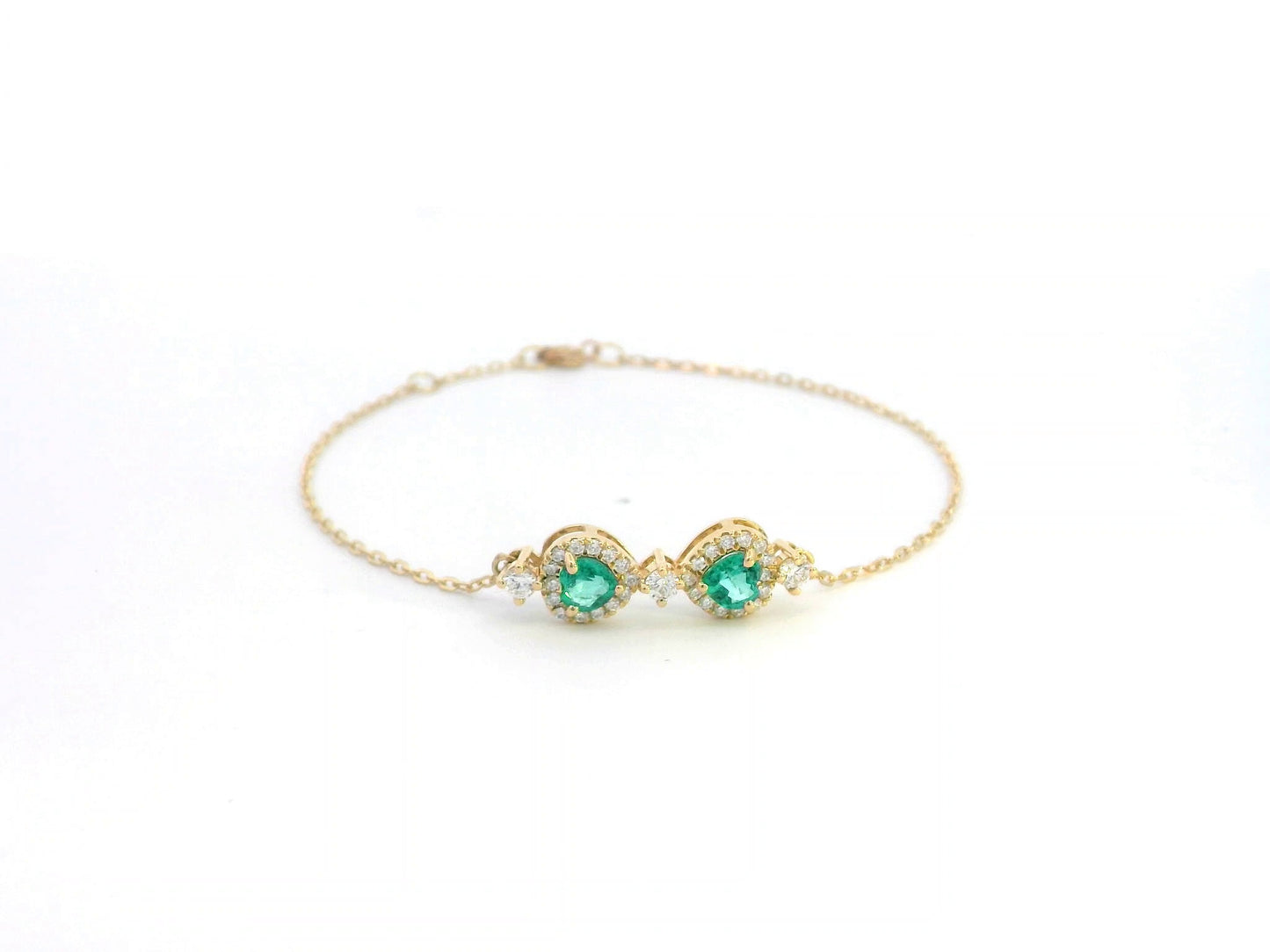 18K gold bracelet featuring two heart-shaped emeralds (0.57ct) with diamond halos (0.38ct) on a delicate chain.