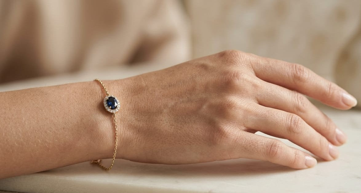 18K yellow gold bracelet with oval blue sapphire centre surrounded by a round diamond halo