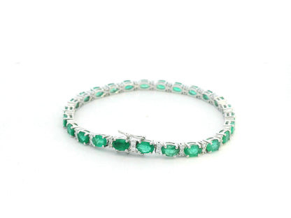 18K white gold tennis bracelet with 8.88ct oval-cut emeralds and 0.80ct diamond accents.