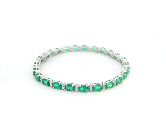 18K white gold tennis bracelet with 8.88ct oval-cut emeralds and 0.80ct diamond accents.