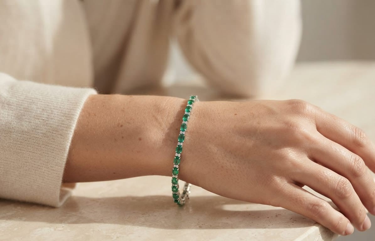 18K white gold emerald and diamond tennis bracelet with oval green emeralds and round diamond accents