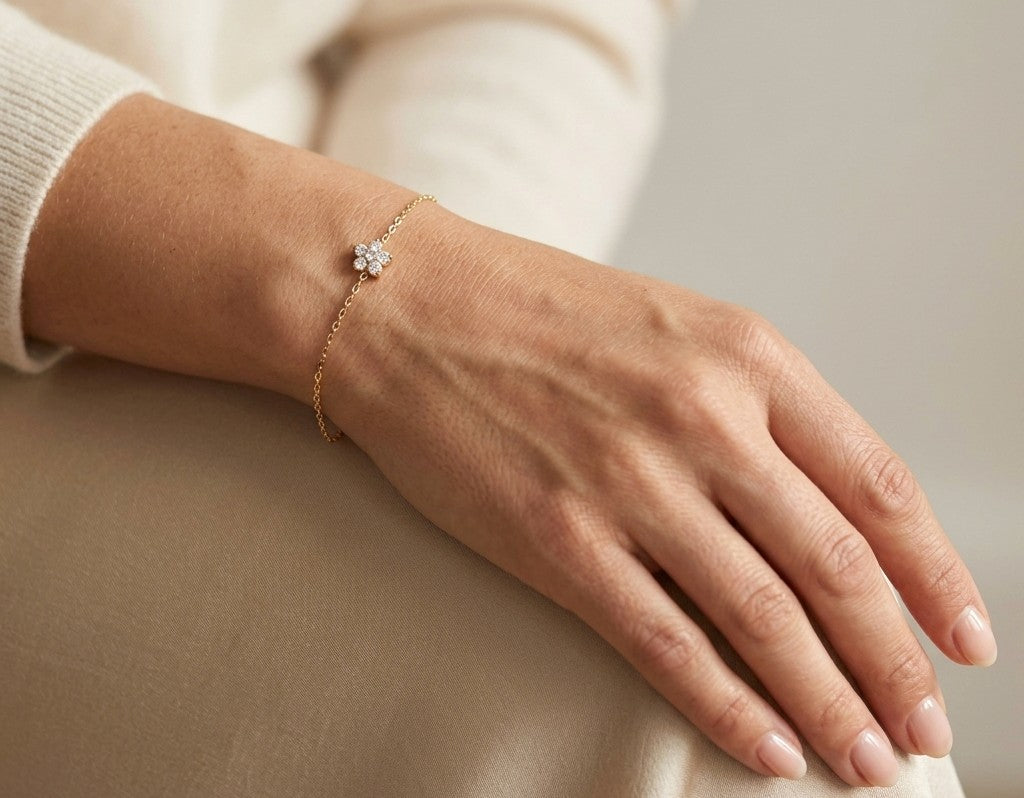 Diamond flower bracelet in 18K yellow gold featuring round brilliant diamonds arranged in a floral centre motif on a fine gold chain.