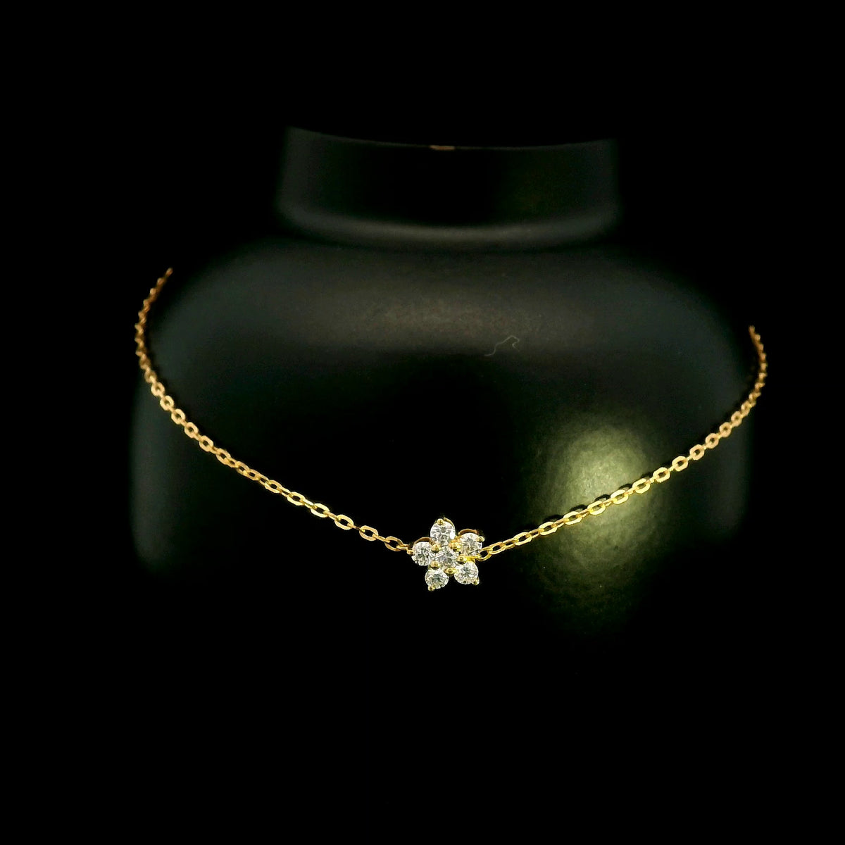 Diamond flower bracelet in 18K yellow gold featuring round brilliant diamonds arranged in a floral centre motif on a fine gold chain.