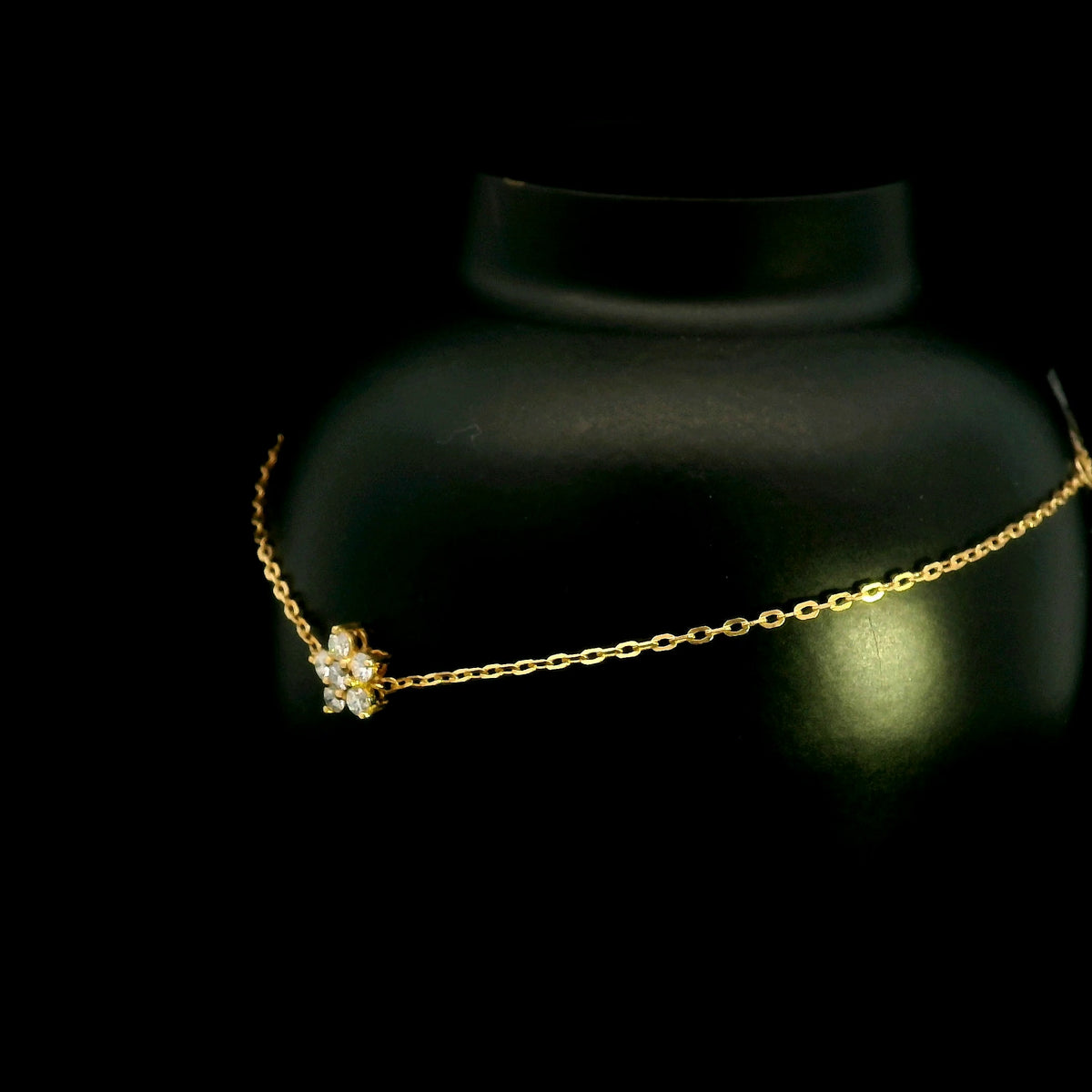 Diamond flower bracelet in 18K yellow gold featuring round brilliant diamonds arranged in a floral centre motif on a fine gold chain.
