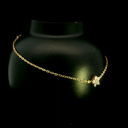 Diamond flower bracelet in 18K yellow gold featuring round brilliant diamonds arranged in a floral centre motif on a fine gold chain.