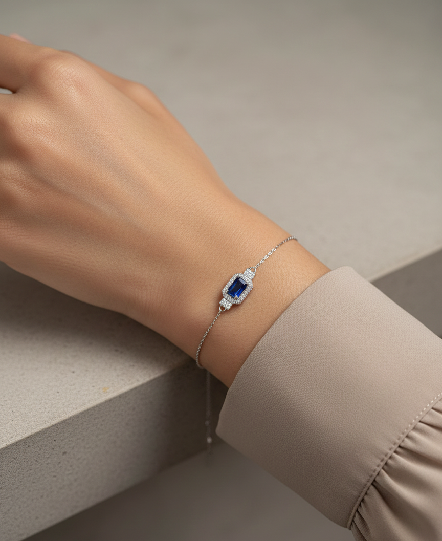 18K white gold sapphire halo bracelet with emerald-cut 0.80ct blue sapphire and diamond accents – Emirates Diamonds.