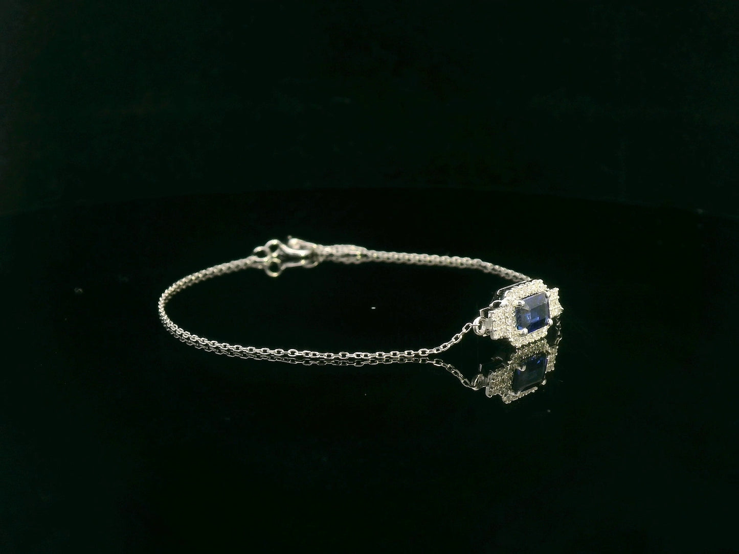 18K white gold sapphire halo bracelet with emerald-cut 0.80ct blue sapphire and diamond accents – Emirates Diamonds.